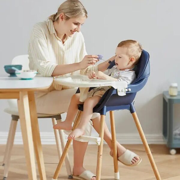 Chaise haute repas bébé évolutive en bleu foncé, avec harnais de sécurité et plateau amovible, idéale pour les repas des enfants.
